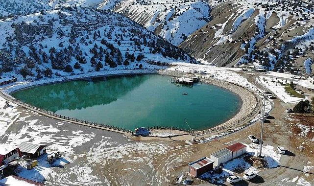 Yüzeyi buz tutan gölde mest eden kış manzarası