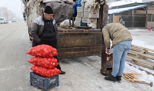 Doğu buz kesti, pazarcılar soğuktan korunmak için soba kurdu