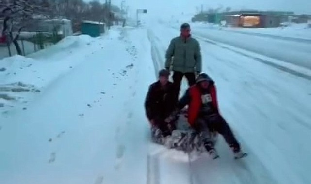 Traktör arkasında karda 'sörf'