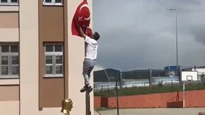 Okul önünde direğe dolanan bayrağı tırmanarak çözdü