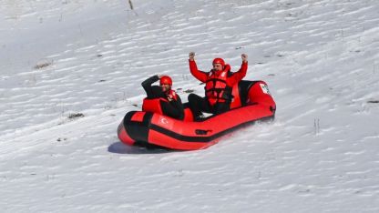 Karla kaplı dağdan donmuş gölete botla kaydılar